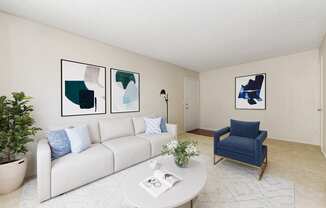 A living room with a white couch, a blue chair, and three framed pictures on the wall.