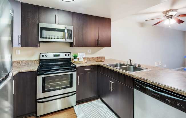 Kitchen with stainless steel appliances and wooden cabinets at Ascend2300, Carlsbad, 92008 