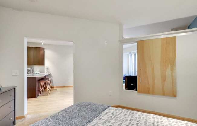 a bedroom with a bed and a doorway to a kitchen