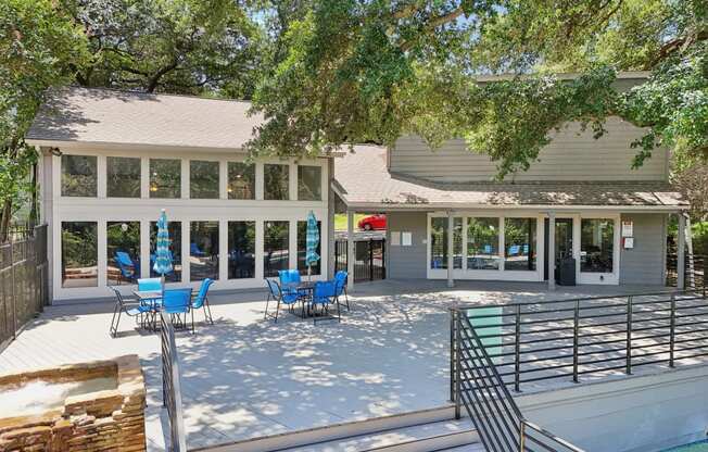 a patio with chairs and a pool in front of a house