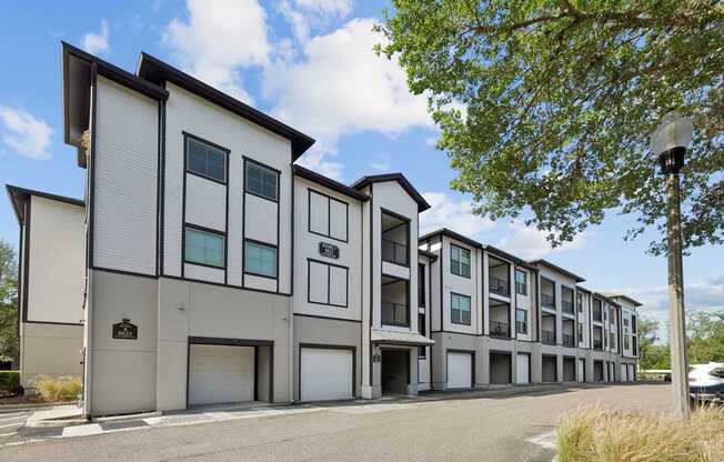 A modern apartment building with a parking lot in front.