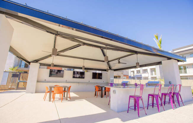 a patio with chairs and a bar and a roof