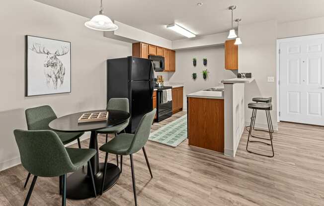 a kitchen and dining area with a black refrigerator and a table and chairs