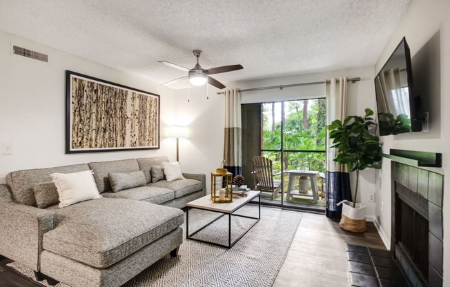 a living room with a couch and a chair and a ceiling fan