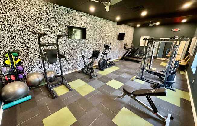 A gym with a variety of equipment including weights and a bench press.