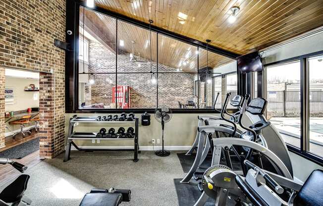 the gym has plenty of cardio equipment and glass windows