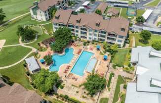 an aerial view of a large swimming pool in a neighborhood with houses