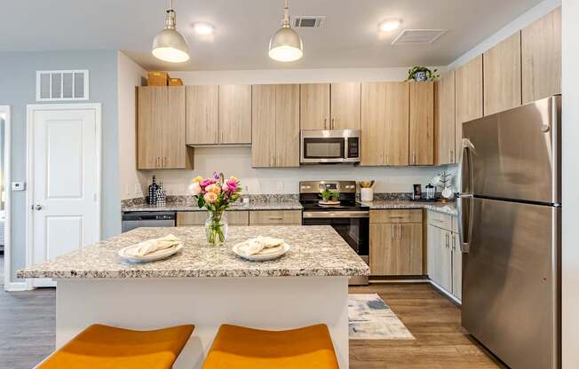 A kitchen with a granite countertop and stainless steel appliances.