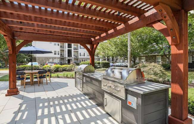 a covered patio with two grills and a wooden pavilion