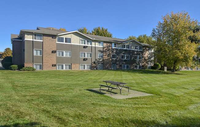 Exterior of a Timberland at Crestbuck Apartment Building Overlooking the Green Grass and Picnic Area