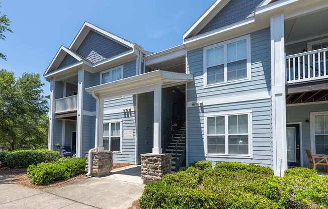 A blue two-story house with a white porch.at Spring Creek Apartments, Crestview
