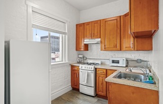 a kitchen with wooden cabinets and white appliances and a window