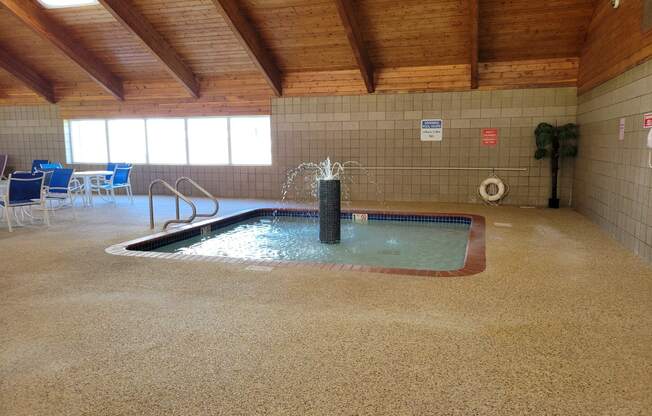 a large indoor jacuzzi in a building with wood ceilings and flooring