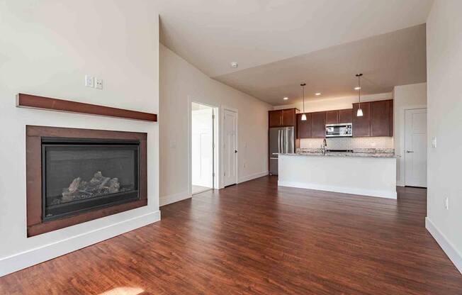 A large open living room with a fireplace and wooden floors.