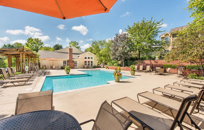 a pool with chairs and tables and a building in the background at Highland Ridge Apartments, Overland Park , 66210