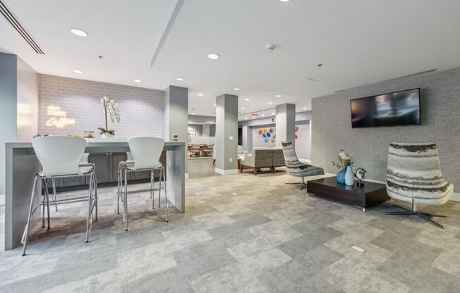 clubroom with a table, chairs, and a television at the Residences at Manchester Place in Manchester, New Hampshire