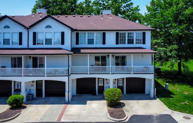 a large white house with a balcony and a driveway