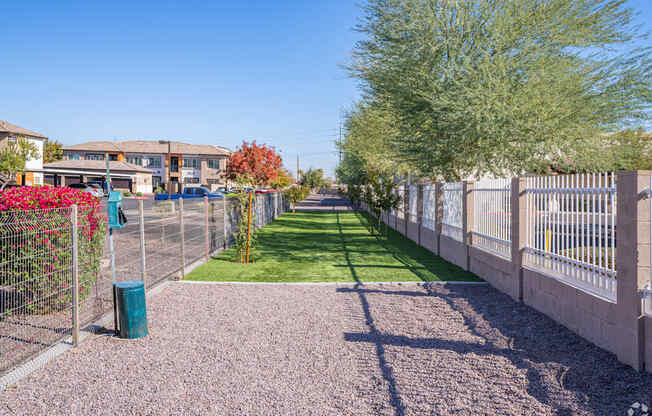 A residential area with a fence and a green lawn.
