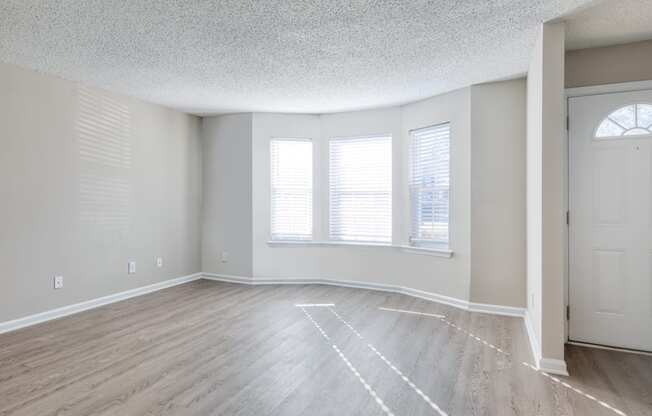 an empty living room with white walls and wood floors