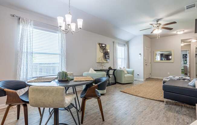 a living and dining room area with a table and chairs and a ceiling fan