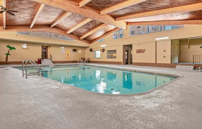 A large indoor swimming pool with a wooden ceiling.