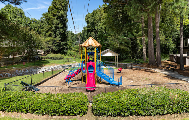 a playground with a colorful swing set in a park