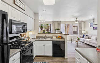 A kitchen with white cabinets and a black stove top oven.
