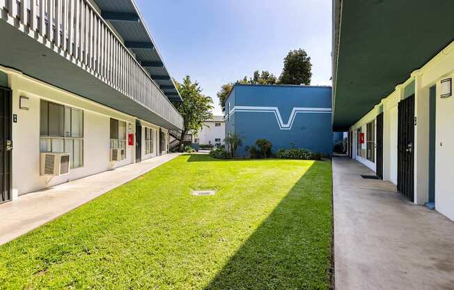 A long grassy area separates two buildings.