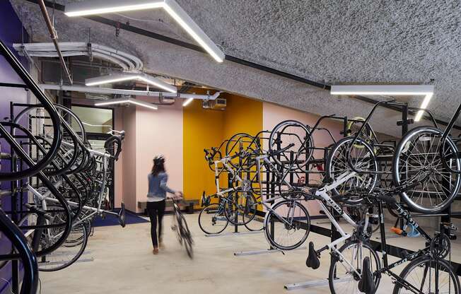 A person walks through a room full of bicycles.
