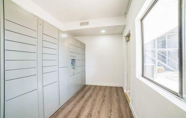 a long hallway with white closets and a window