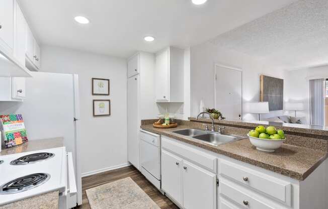 a kitchen with white cabinets and a counter top and a sink