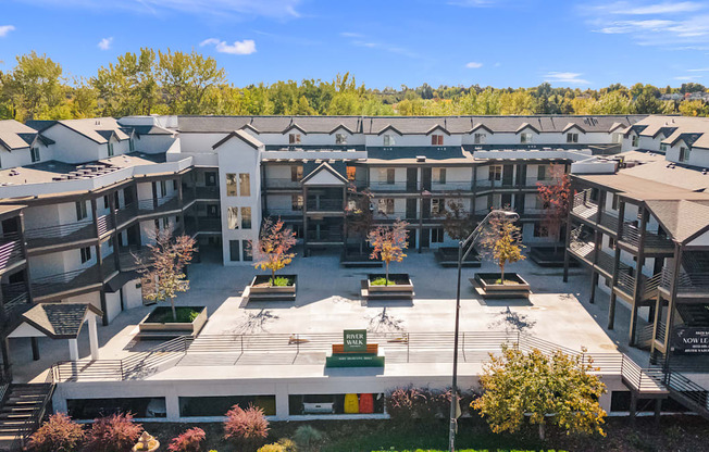 an aerial view of an apartment complex with trees in the background