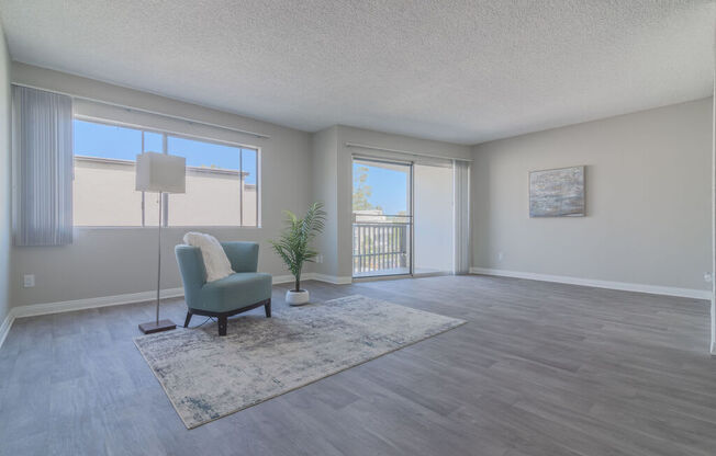 an empty living room with a chair and a rug at Citra Apartments LLC, San Diego