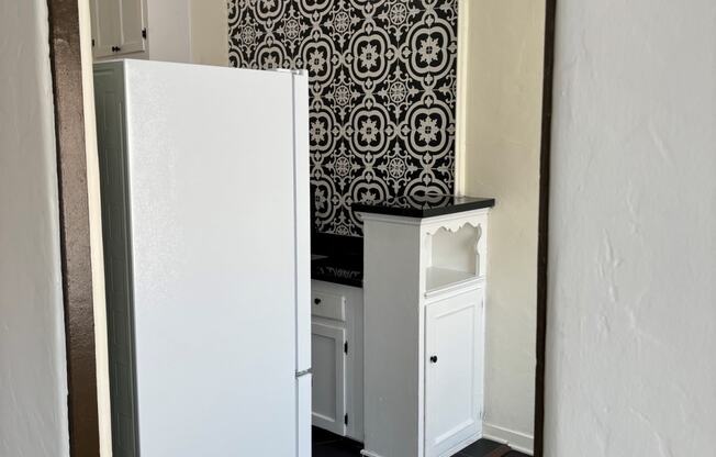 a small kitchen with a white refrigerator and a sink