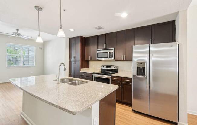 A kitchen with a granite countertop and stainless steel appliances.