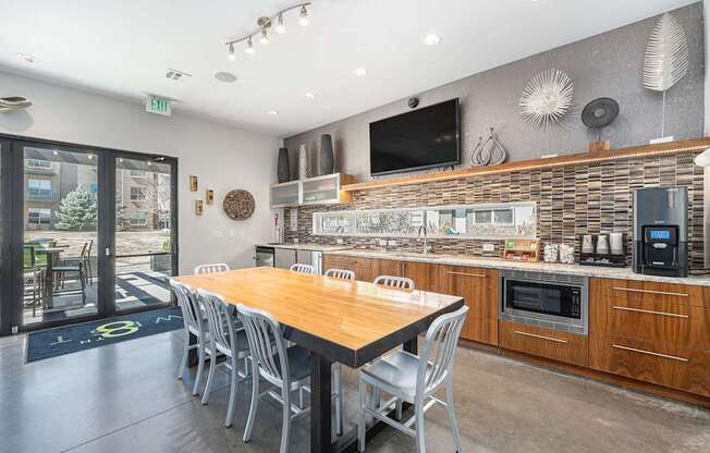 A modern kitchen with a wooden table and chairs.