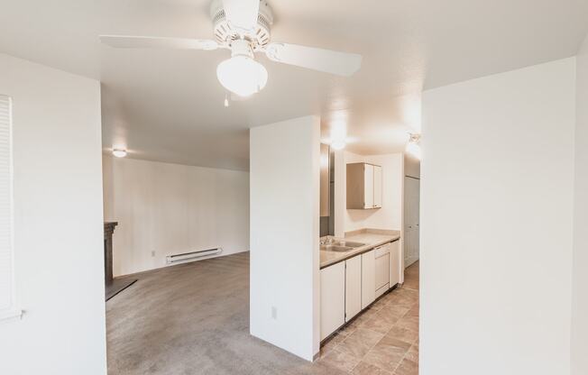 a kitchen and living room with a ceiling fan