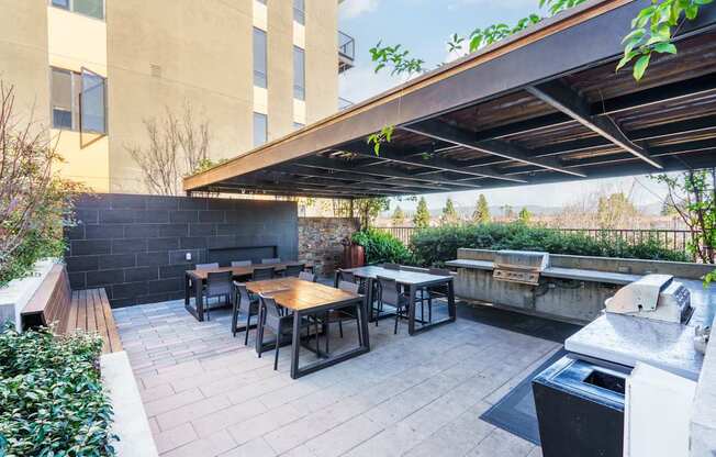 A patio with a table and chairs under a roof.