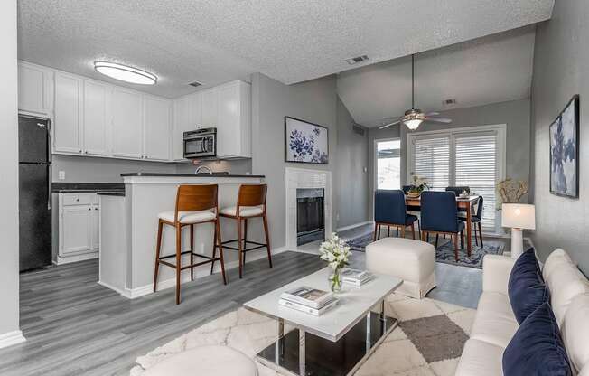 A modern kitchen with white cabinets and a bar area.