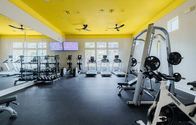 a gym with weights and other exercise equipment and windows