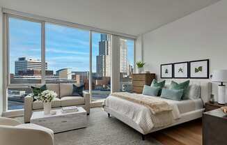 A bedroom with a large bed and a view of the city.