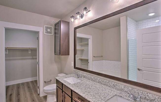 a bathroom with a sink and a large mirror at Hunters Creek Apartments, Denton