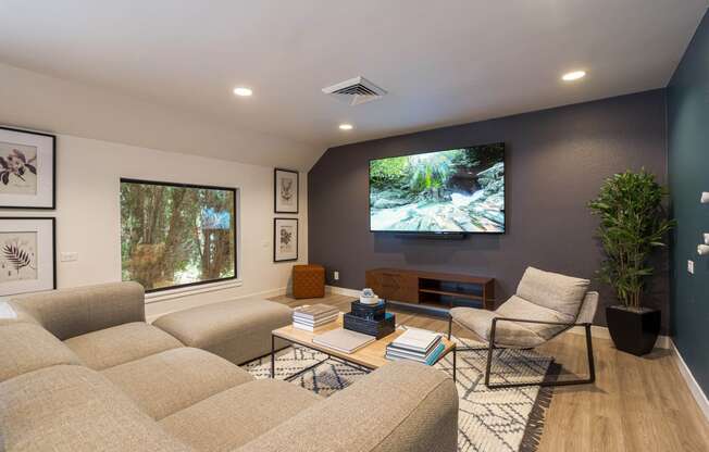 a living room with a large screen tv on the wall