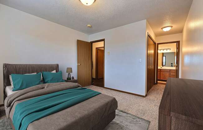 Fargo, ND Flagstone Apartments. a bedroom with a bed and a dresser