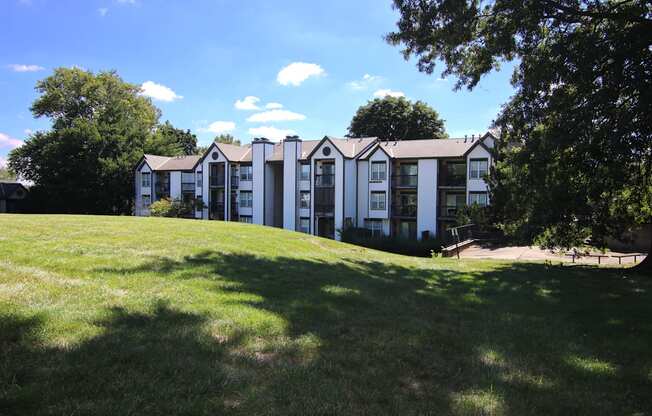 A row of white houses with green lawns in front.