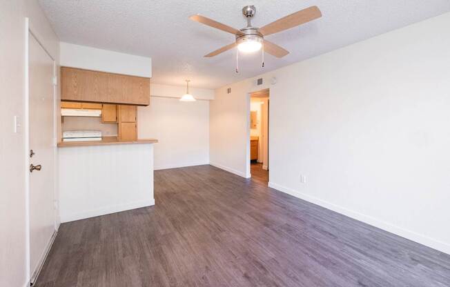 A room with a ceiling fan and wooden flooring.