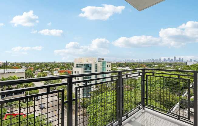 Private apartment balcony at MB Station overlooking Coral Way with expansive city skyline views near Brickell and Downtown Miami.