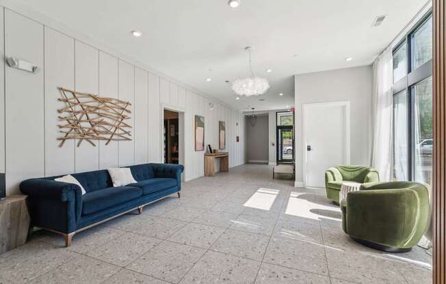 A spacious waiting area with a blue sofa, green armchair, and a wooden wall art.