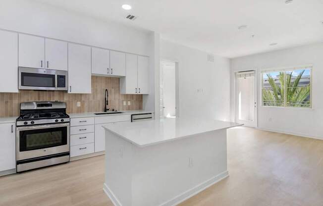 A modern kitchen with white cabinets and a large island.