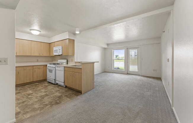 A kitchen with wooden cabinets and a white dishwasher at Fieldstream Apartment Homes, Iowa
